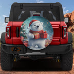 Winter Wonderland polar bear spare tire cover mounted on a red Jeep Bronco rear with snowy gift box scene