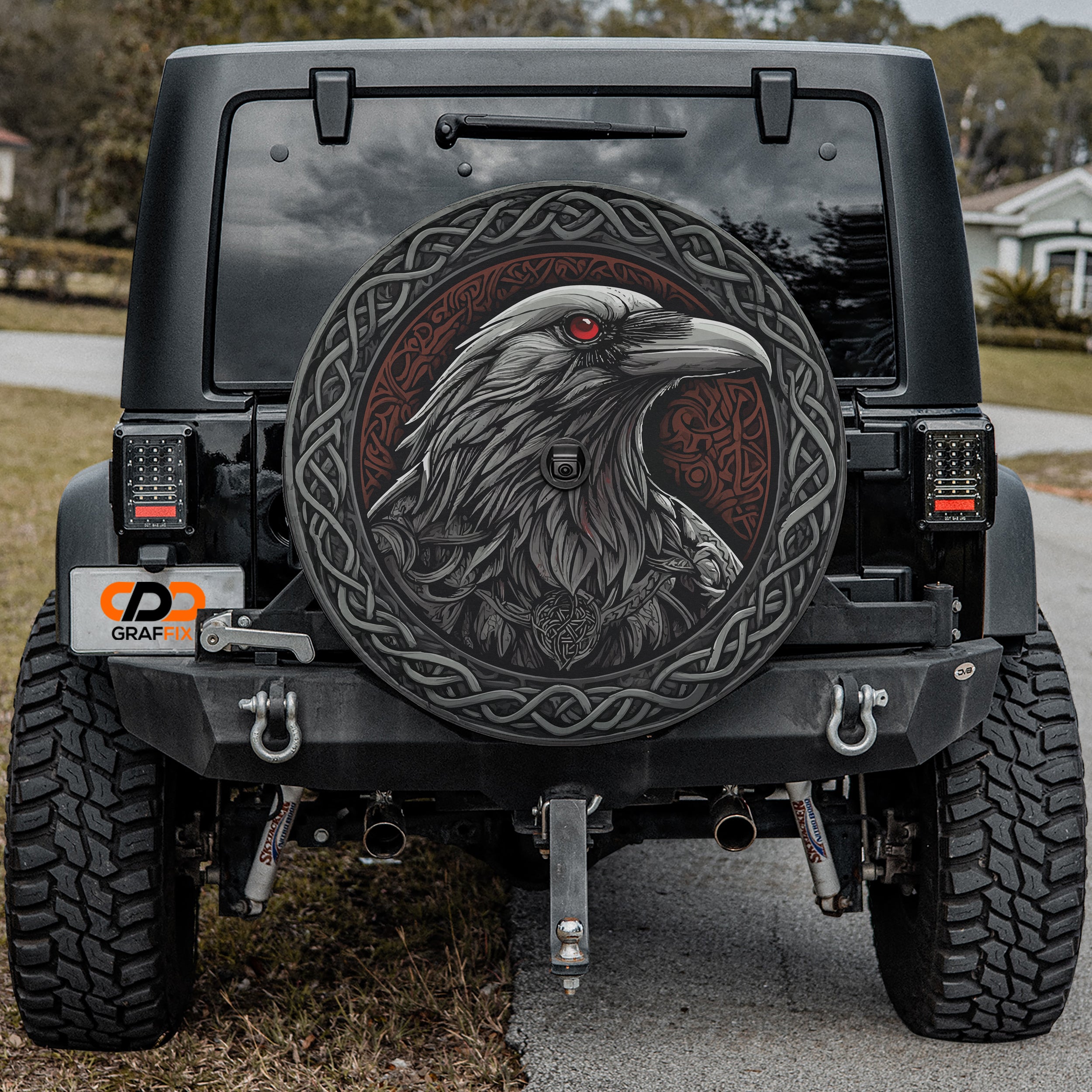 Odin's ravens spare tire cover installed on a black Jeep Wrangler with GRAFFIX rear bumper sticker