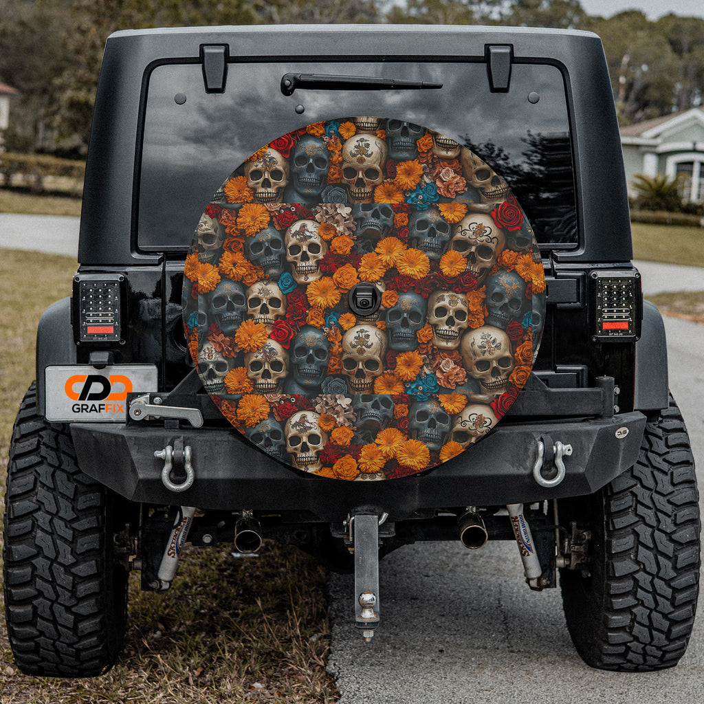 Flowers and skulls tire cover on black Jeep Wrangler with orange marigolds, red roses, and weathered skulls