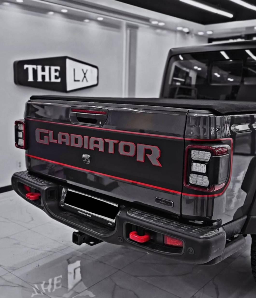 Red bordered blackout tailgate decal on dark Jeep Gladiator JT inside showroom display