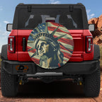 Lady Liberty's Glory spare tire cover mounted on a red Ford Bronco with desert canyon backdrop