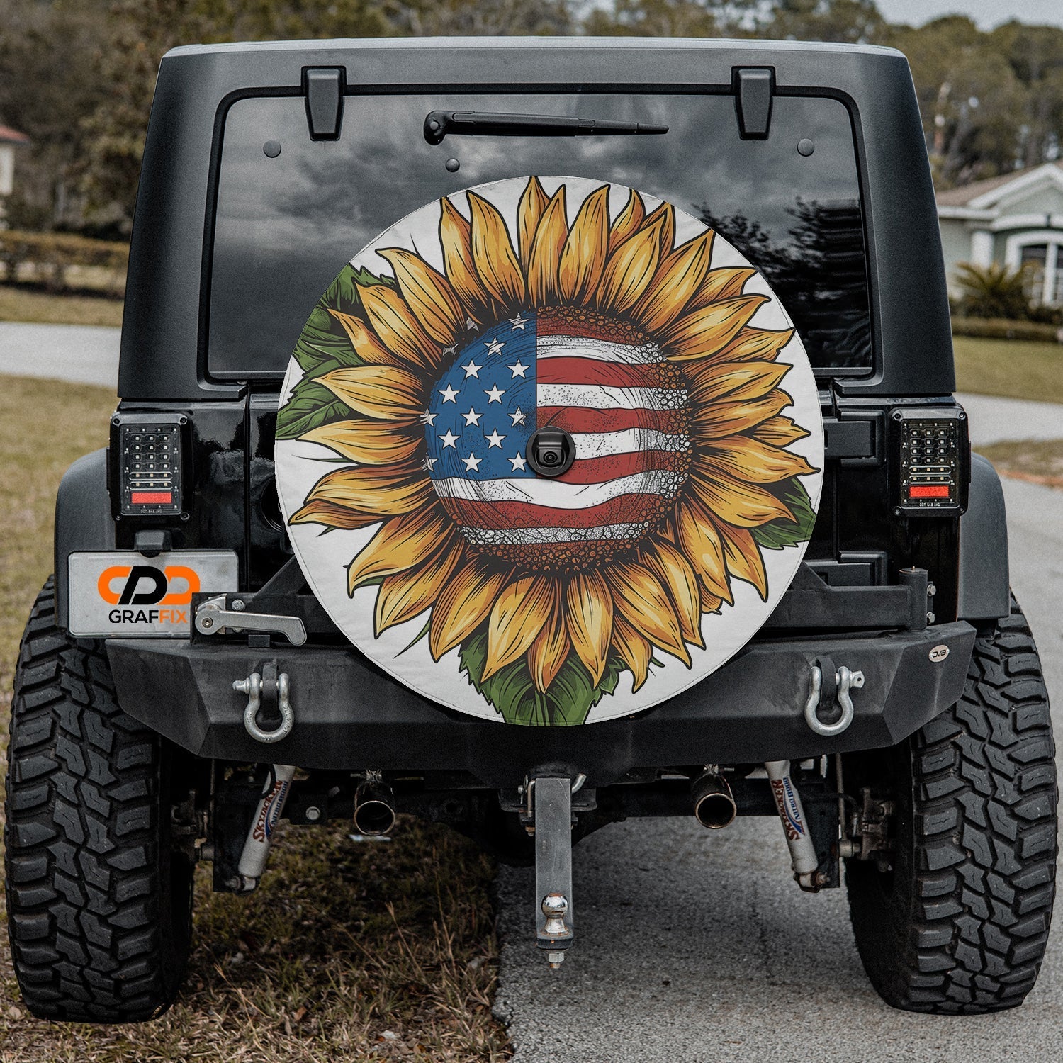 Star-Spangled Sunflower spare tire cover mounted on a Jeep Wrangler showcasing the patriotic sunflower in outdoor light