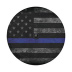 Flat round thin blue line subdued flag tire cover closeup with weathered grayscale stars and blue stripe
