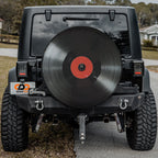 Vinyl Record spare tire cover mounted on red Jeep Wrangler rear gate showing detailed LP record art