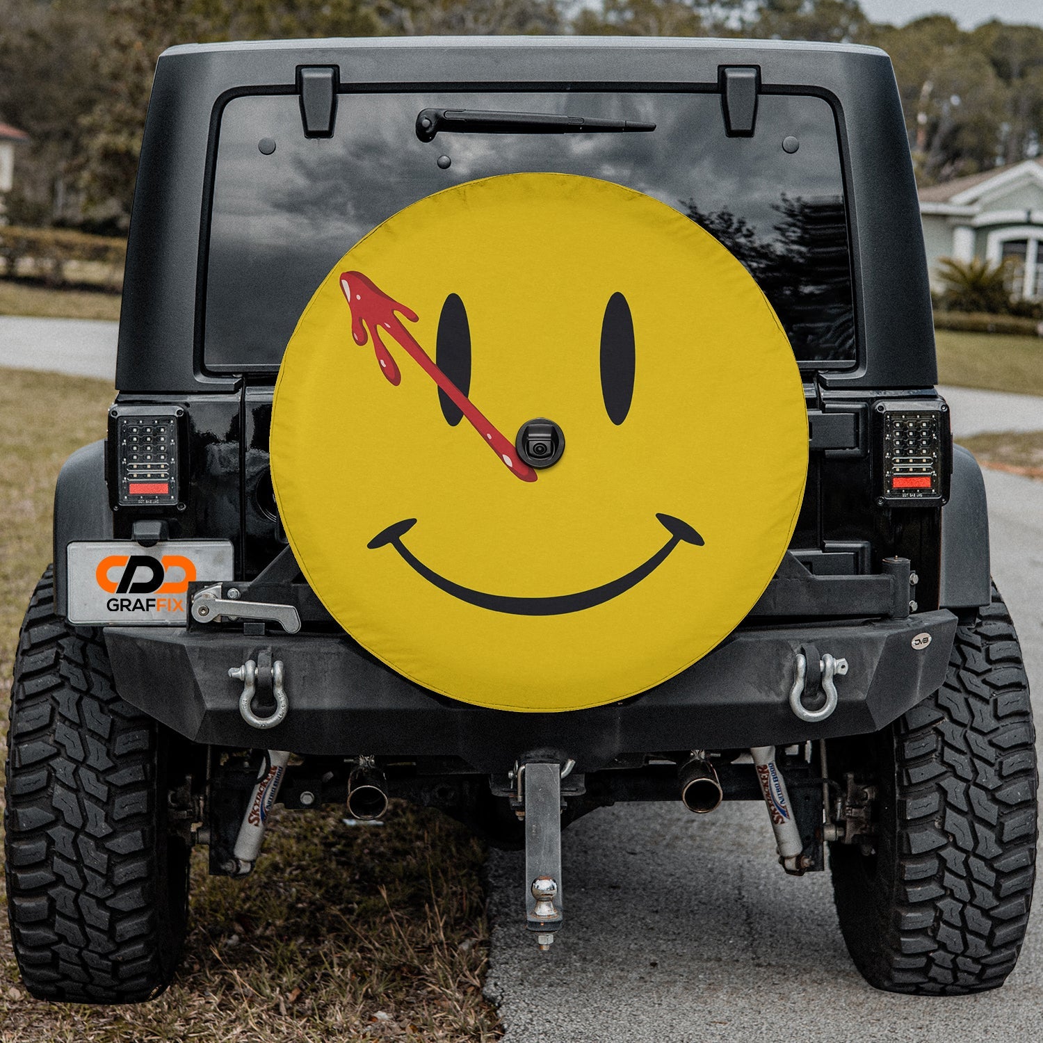 Comedian Smiley Face spare tire cover Jeep rear mount close up showing yellow face and red blood spray