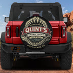 a red Jeep Wrangler with a shark-themed spare tire cover on the rear of the vehicle.
