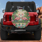 A red Jeep Wrangler with a large, colorful wheel cover featuring a pair of flamingos in a tropical setting.