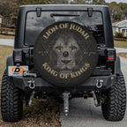 a black Jeep Wrangler with a large, round spare tire cover on the rear of the vehicle.