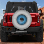 Eye On You spare tire cover on a red Jeep Wrangler showing a blue iris design on the rear-mounted spare wheel