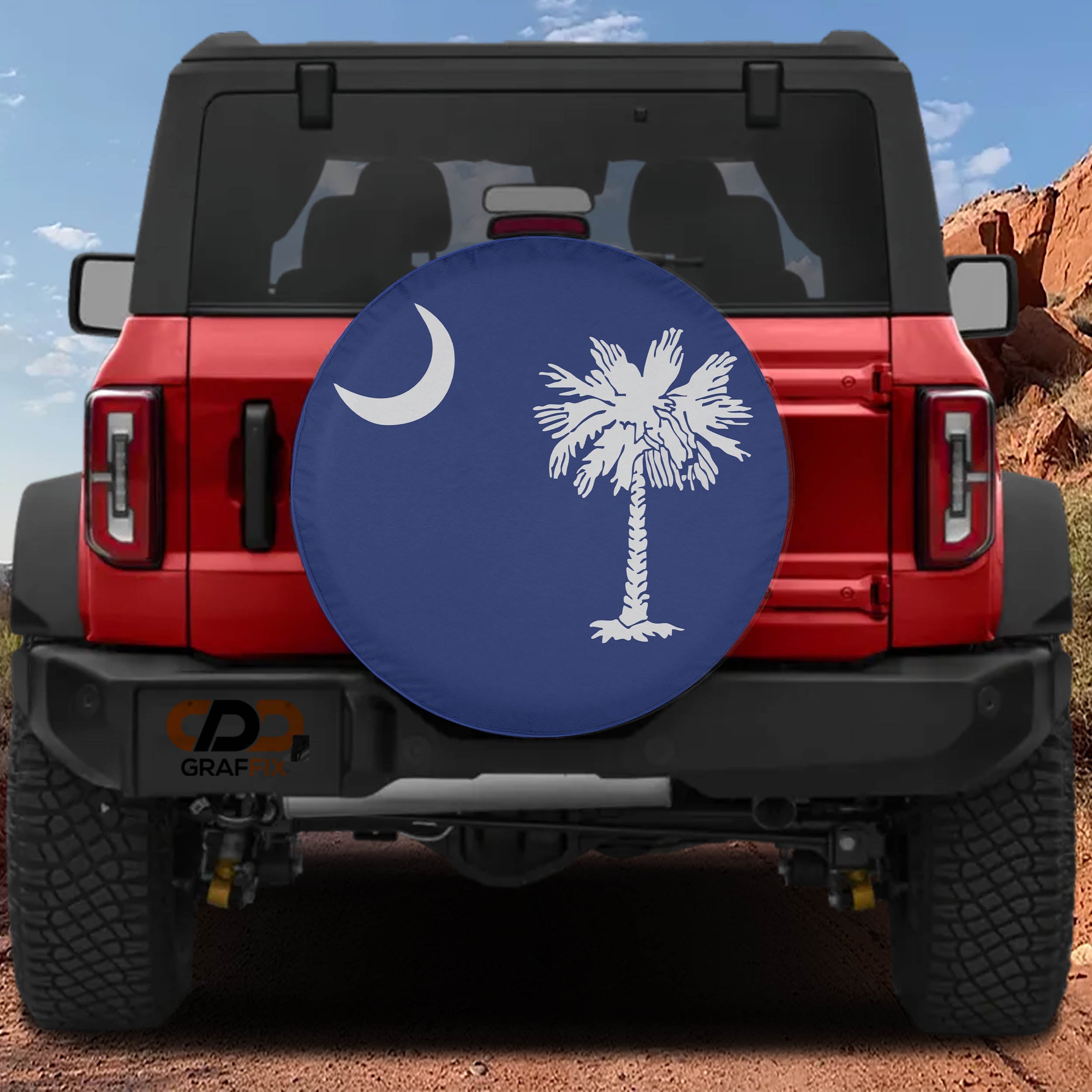 South Carolina palmetto moon spare tire cover mounted on red Ford Bronco rear against red rock backdrop