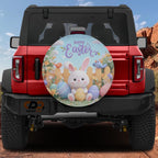 a red Jeep Wrangler with a large Easter-themed wheel cover attached to the rear. The cover depicts a bunny holding Easter eggs and is surrounded by a colorful Easter landscape.