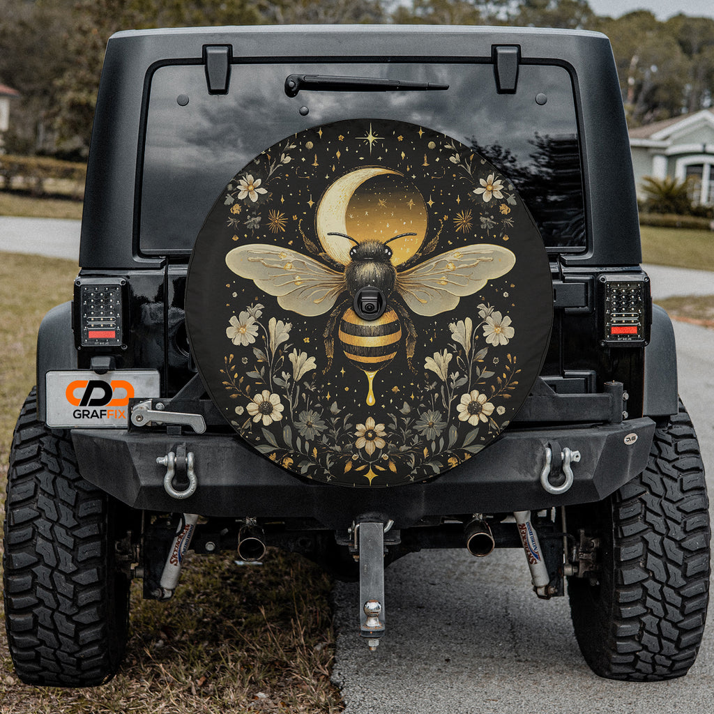 Celestial Buzz bee tire cover on a black Jeep rear with golden moon bee, stars and floral wreath art