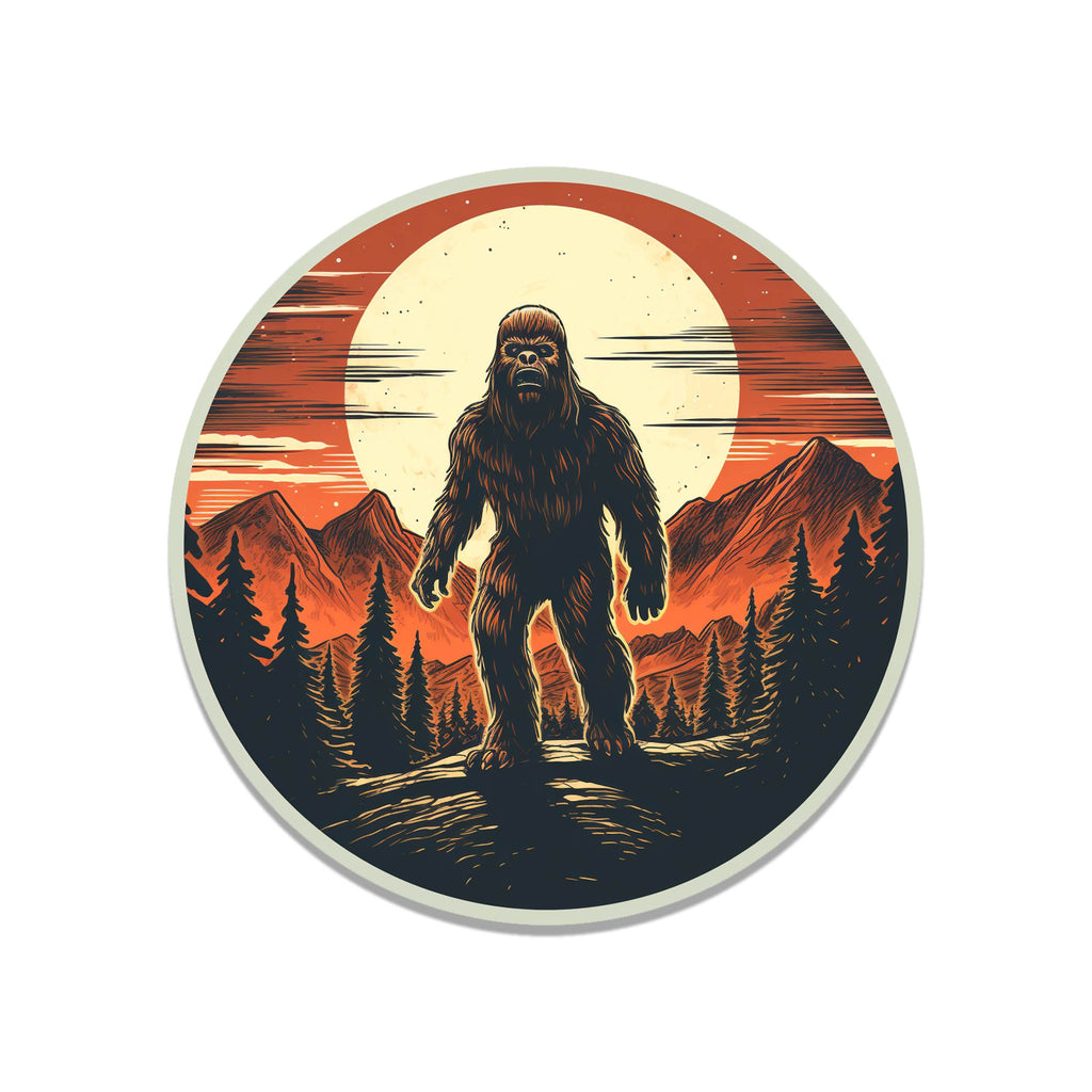 Round Bigfoot wilderness sticker with silhouette standing in pine forest under orange sun and red sunset