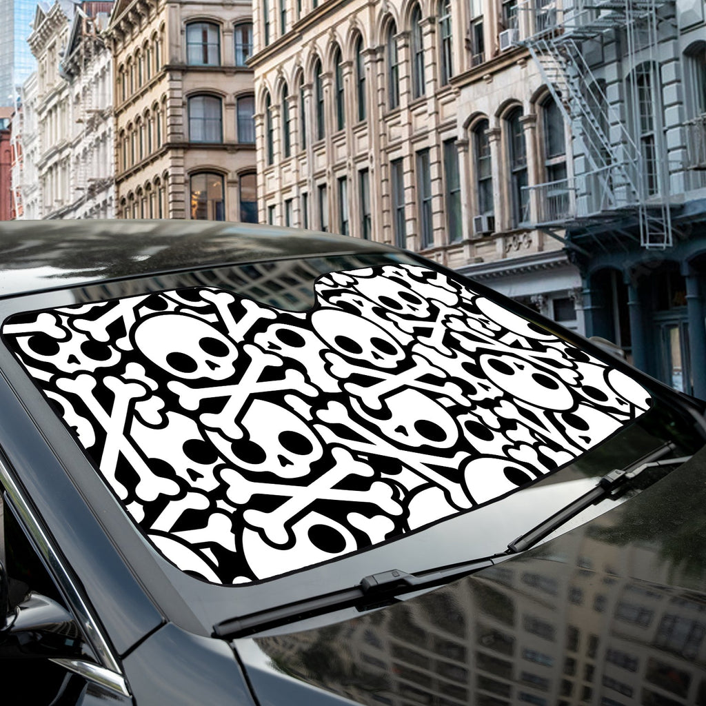 Skull and Crossbones accordion sunshade close-up installed on a dark sedan windshield exterior detail