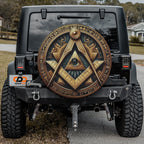 the back of a black Jeep Wrangler with a large, ornate wheel cover featuring an Egyptian-inspired design.