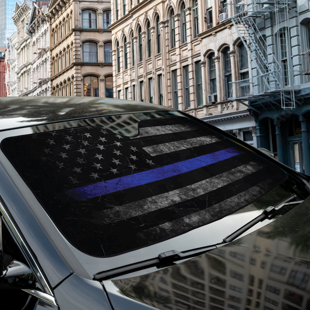 Thin Blue Line American Flag accordion sunshade close-up installed on a dark sedan windshield exterior view