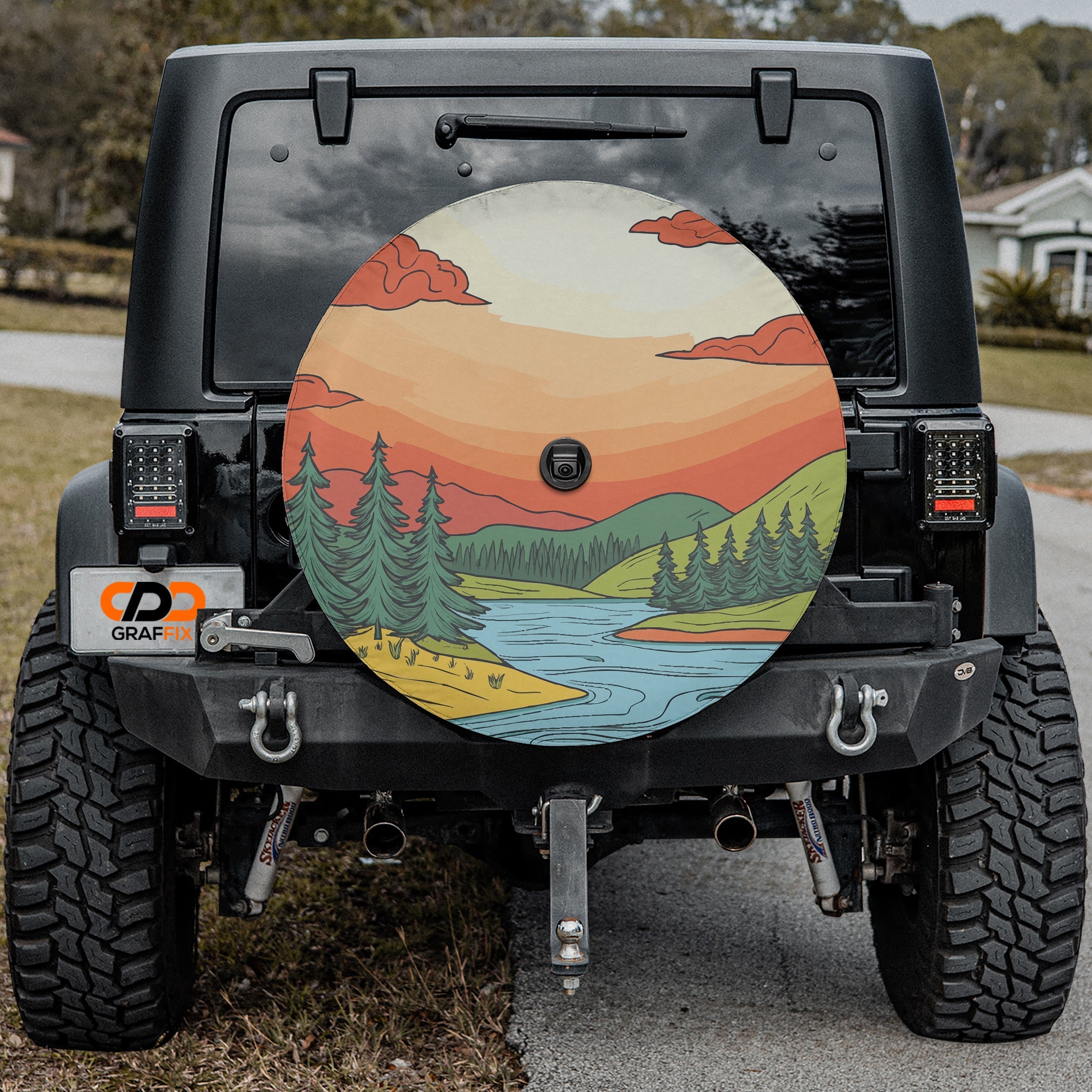 Close-up sunset landscape spare tire cover disc with pine trees, river, mountain art and camera hole