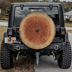 a black Jeep Wrangler with a large tree trunk mounted on the rear of the vehicle.