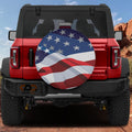 Wavy American flag stars and stripes spare tire cover on red Ford Bronco SUV in red rock desert