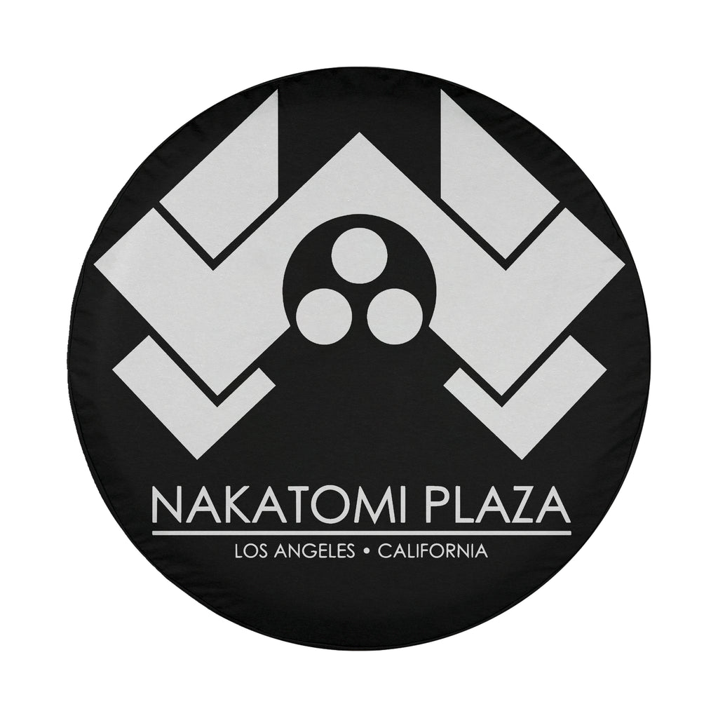 Round Nakatomi Plaza spare tire cover with white chevron logo and Los Angeles California text on black