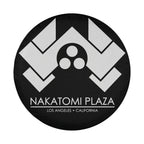Round Nakatomi Plaza spare tire cover with white chevron logo and Los Angeles California text on black