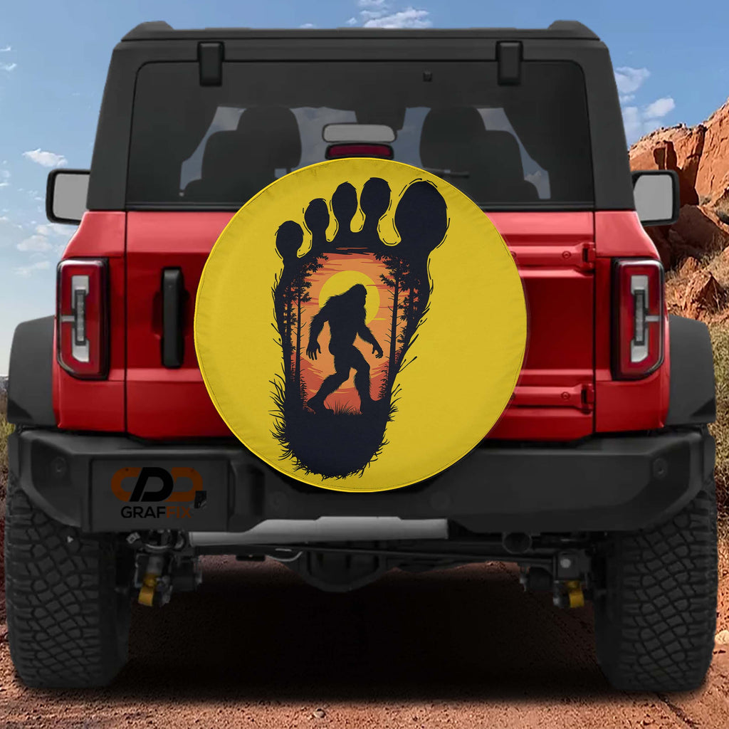 Squatch Track spare tire cover on red Bronco with yellow Bigfoot footprint sunset silhouette design