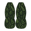 two identical car seat covers with a repeating pattern of green leaves and branches.
