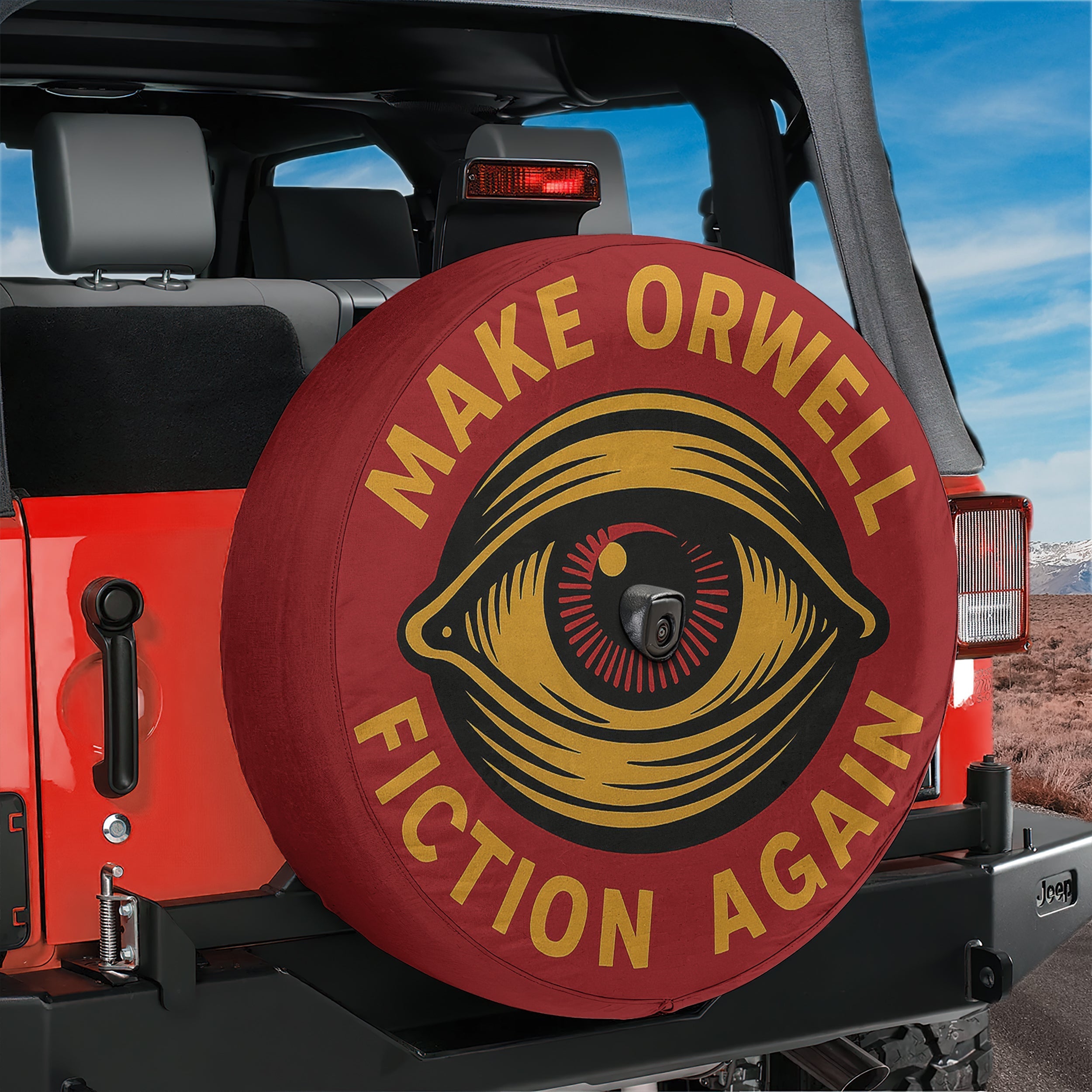 A red Jeep Wrangler with a large tire cover featuring a black and yellow design and the text "Make Orwell Fiction Again" attached to it.