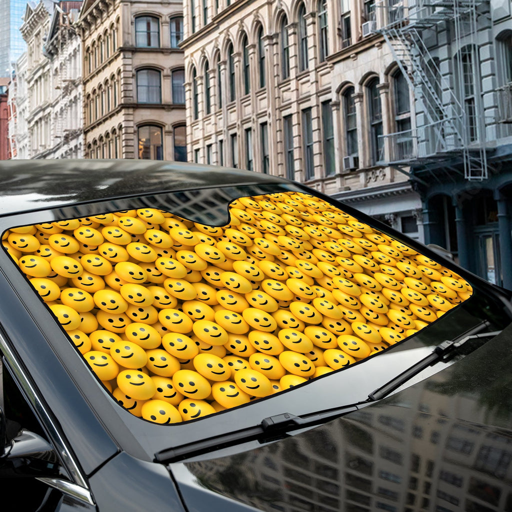Happy Smiley Faces accordion sunshade close-up installed on a dark sedan windshield exterior detail view