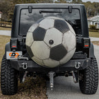 Soccer ball black and white spare tire cover mounted on black Jeep Wrangler rear outdoors