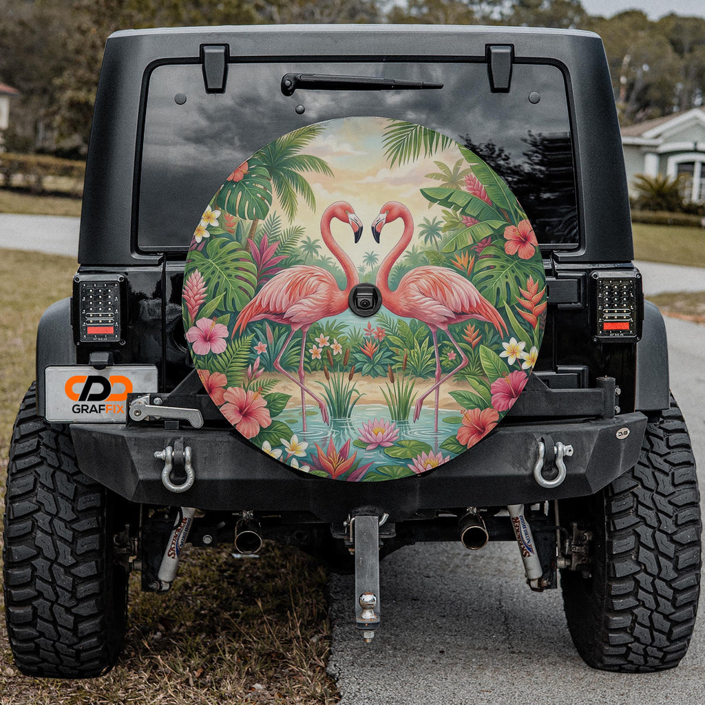 a black Jeep Wrangler with a large, colorful wheel cover depicting a tropical scene with two pink flamingos standing in a pond surrounded by lush greenery.