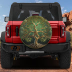 Yggdrasil Tree of Life green forest spare tire cover mounted on red Jeep Wrangler rear gate at desert