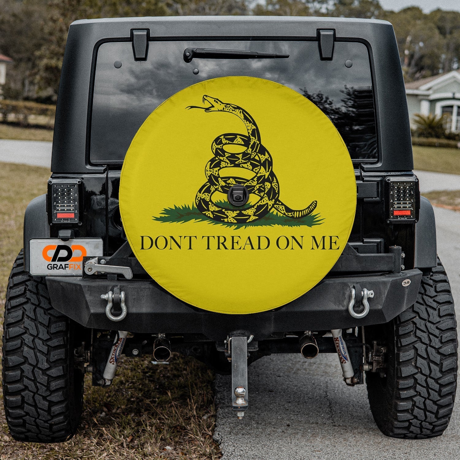 Gadsden flag tire cover on black Jeep Wrangler with timber rattler and Don't Tread on Me text on yellow
