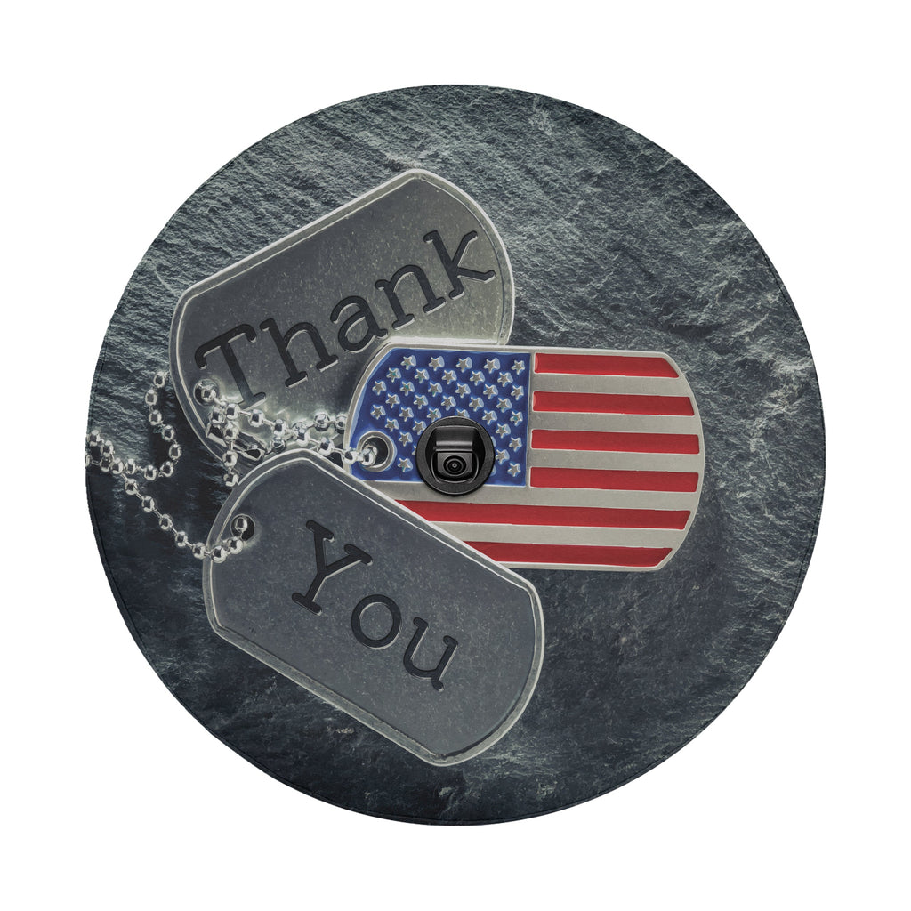 Close-up veterans tribute spare tire cover disc with USA flag dog tags, Thank You text and backup camera hole