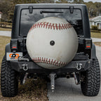 Baseball spare tire cover mounted on black Jeep Wrangler rear with backup camera cutout