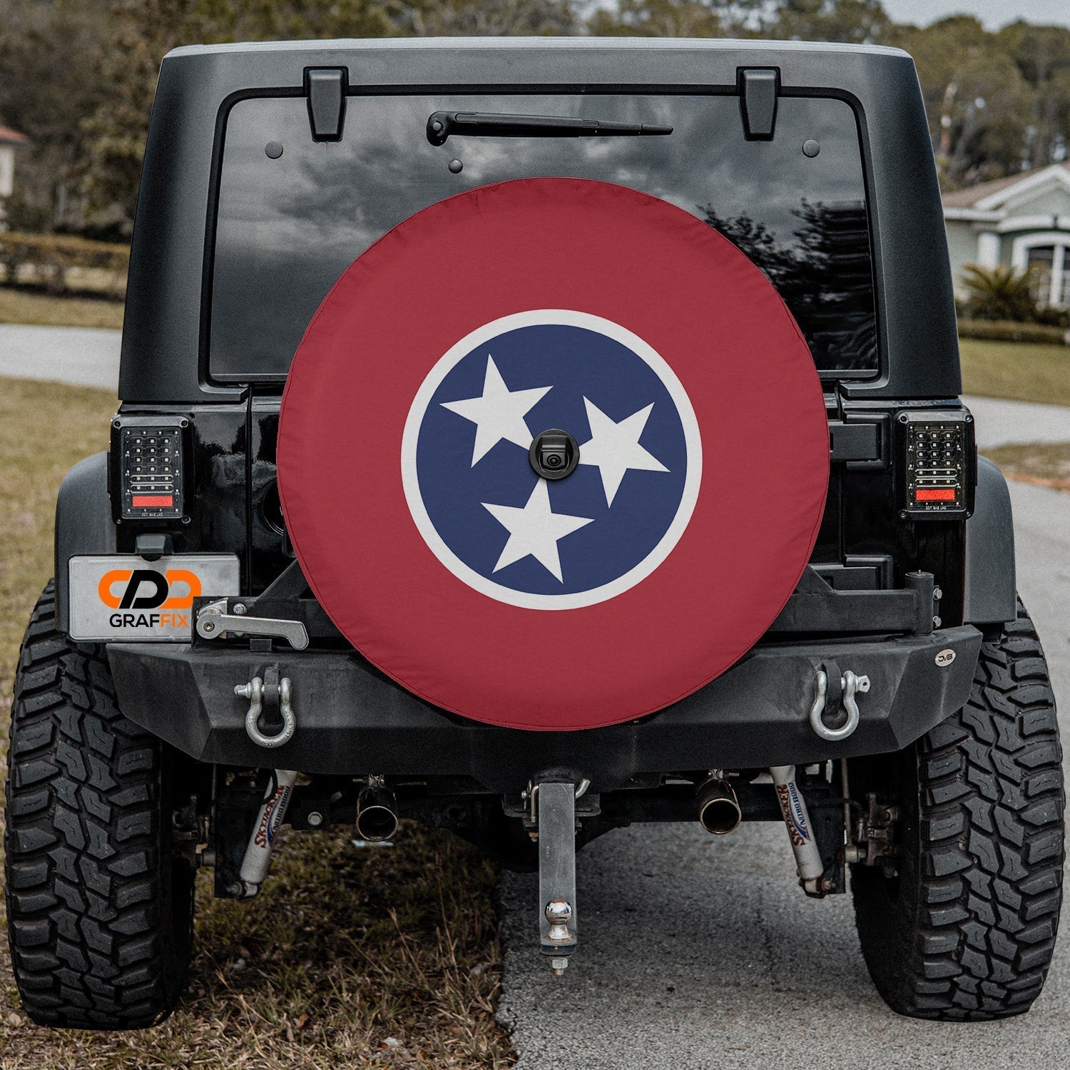 Tennessee state flag spare tire cover on red Jeep Wrangler with desert backdrop featuring three-star emblem