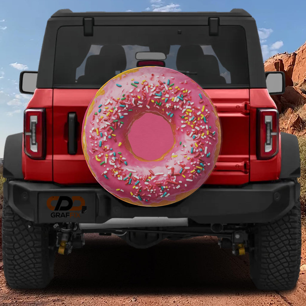A red Jeep Wrangler with a large pink donut-shaped air freshener attached to the rear.