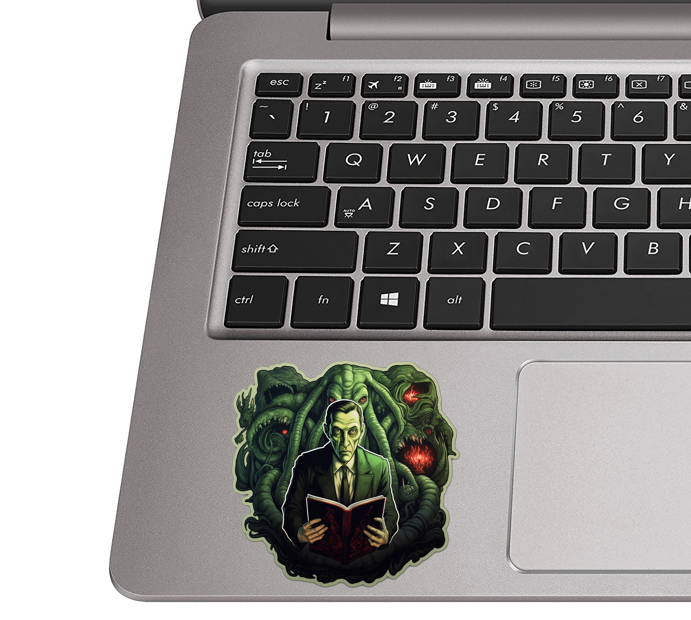 HP Lovecraft Cthulhu Mythos sticker on silver laptop palm rest near black QWERTY keyboard for scale reference
