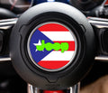 Puerto Rico flag center-cap overlay with lime-green Jeep wordmark on a black Wrangler steering wheel hub