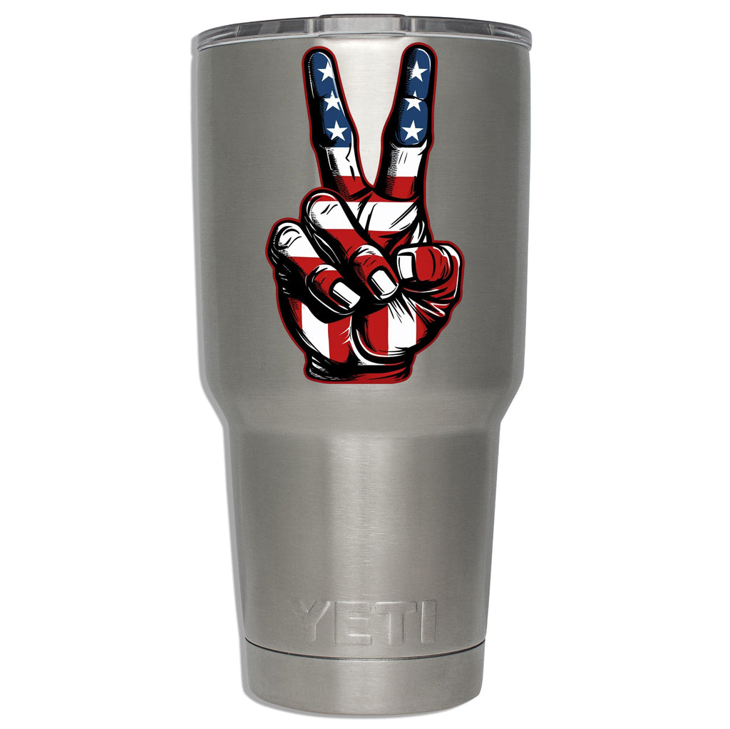 American-flag peace-sign decal mounted on a stainless YETI tumbler to show sticker size on insulated drinkware