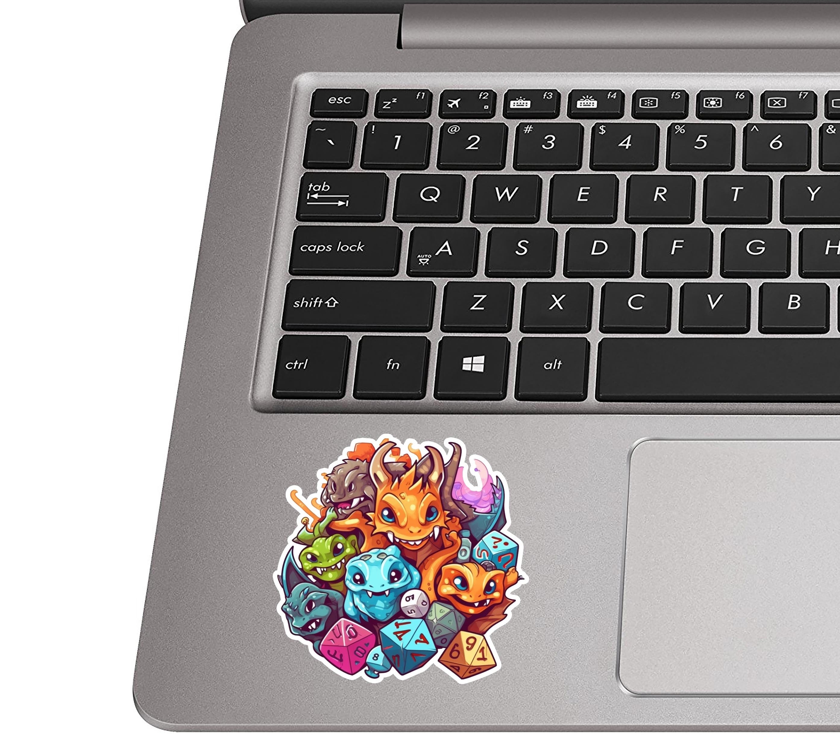 RPG dragon and monsters sticker resting on a silver laptop palm rest near the trackpad for size context