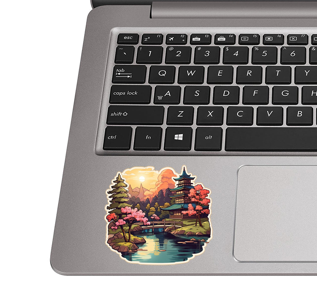 Japanese garden scene sticker placed on a silver laptop palm rest near the trackpad to show sticker scale