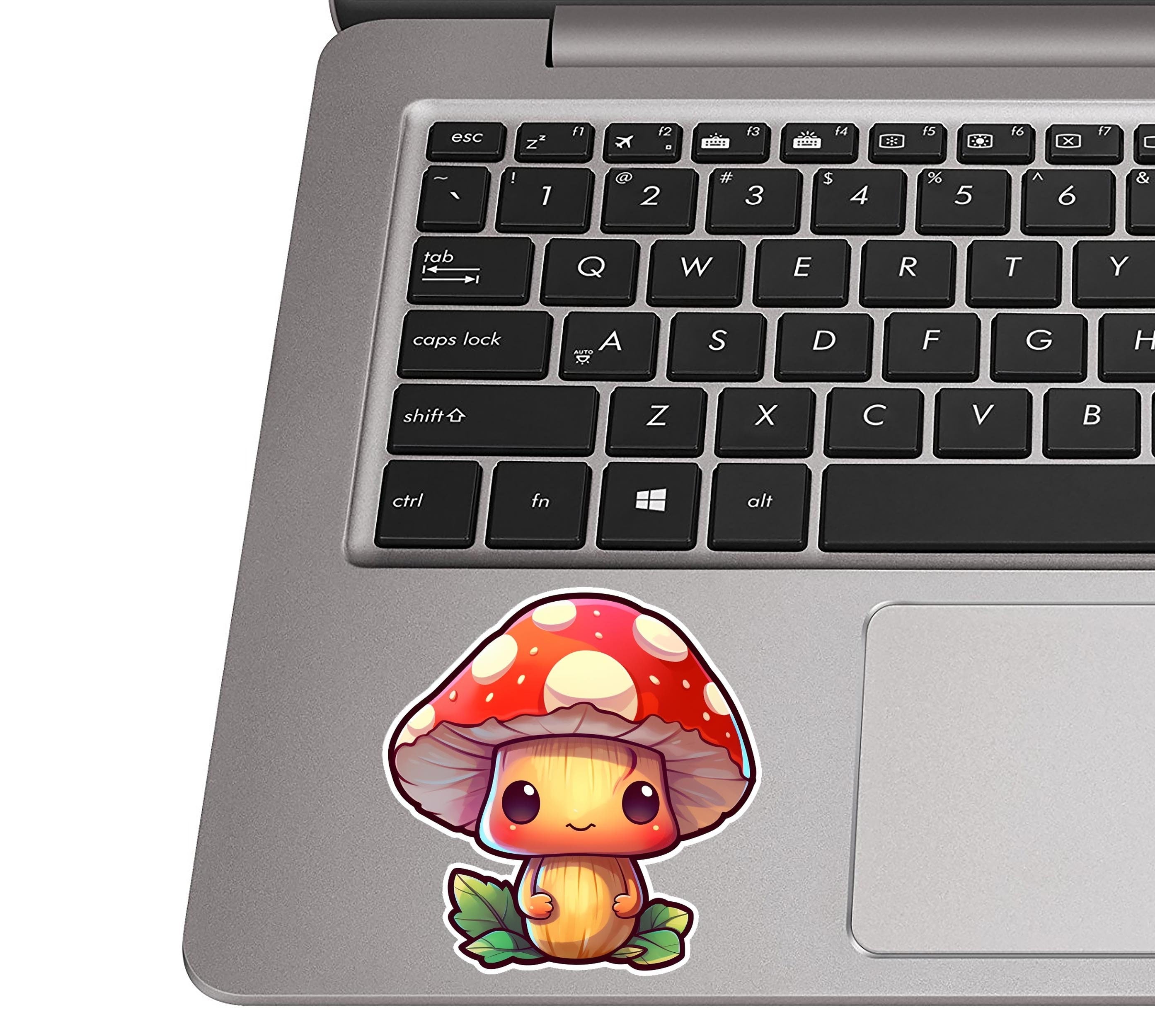 Chibi red cap mushroom sticker on a silver laptop palm rest near a black QWERTY keyboard for scale