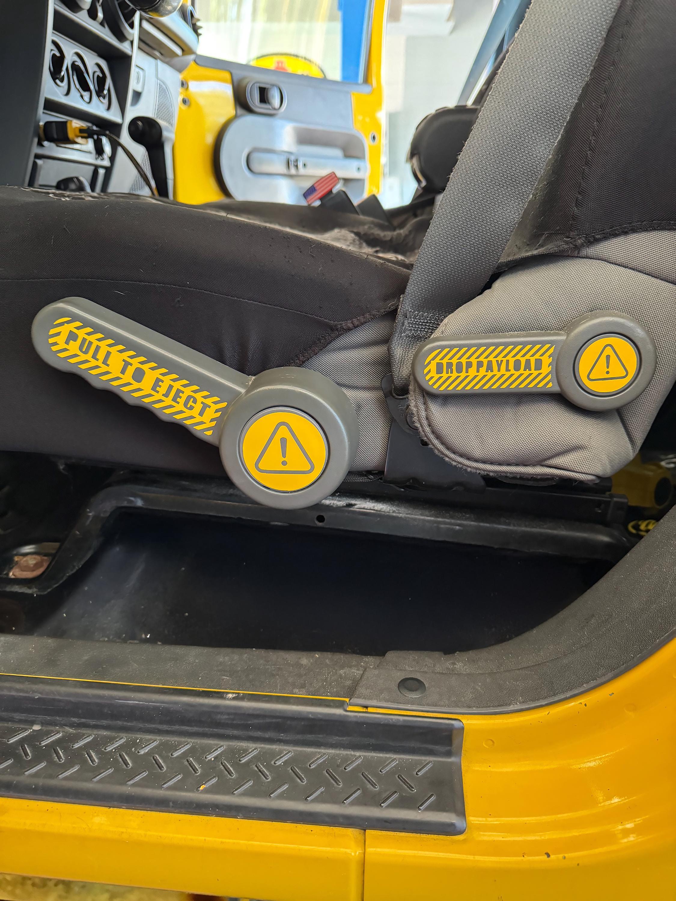 Yellow Pull to Eject seat recliner handle decal pair installed on yellow Jeep Wrangler JK seats