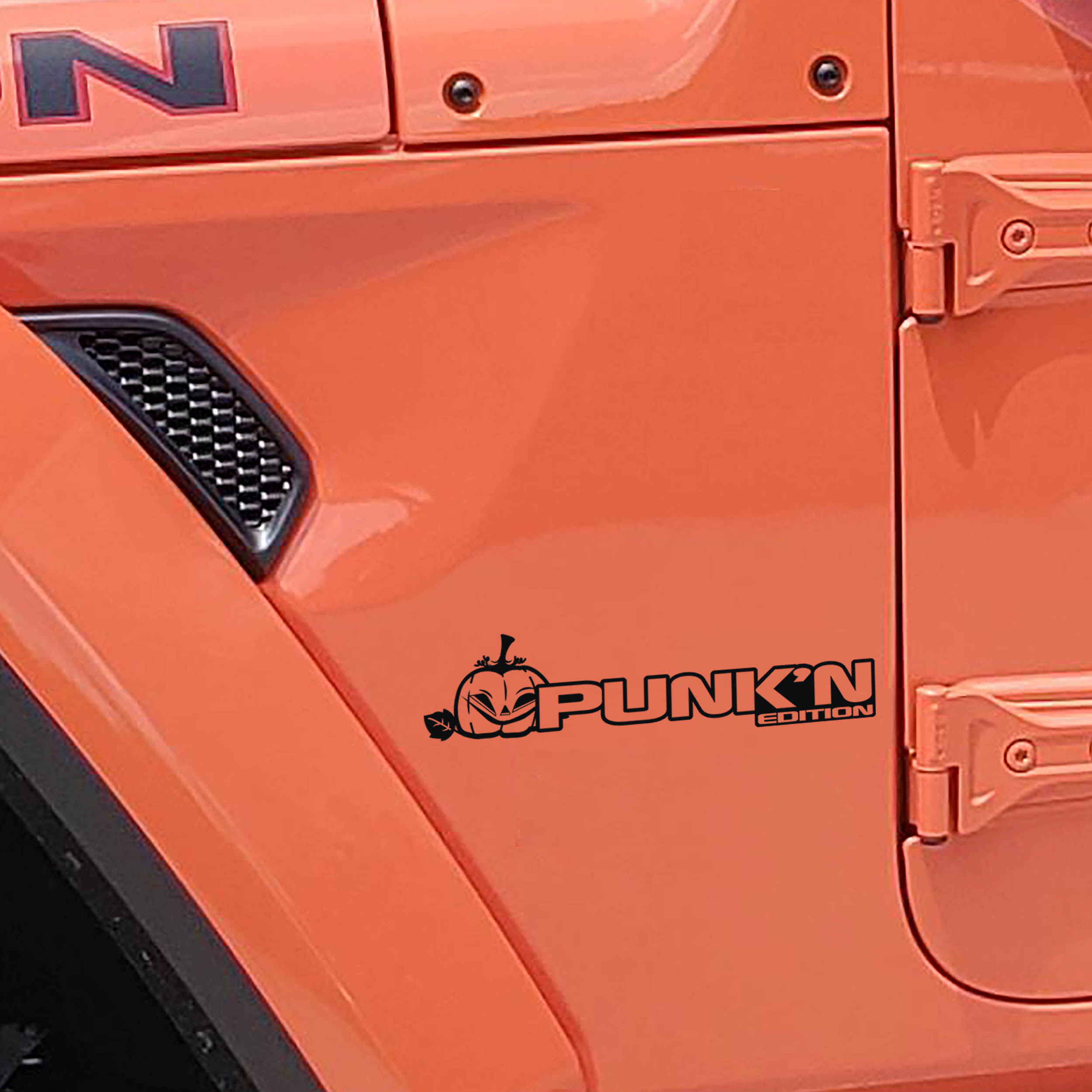 Black Punk'n Edition pumpkin fender decal pair installed on orange Jeep Wrangler JL JT cowl