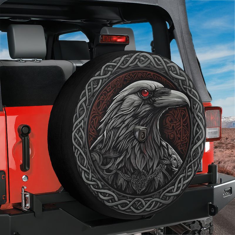 Odin's ravens Huginn and Muninn spare tire cover on a red Jeep Wrangler tailgate with desert mountain scene