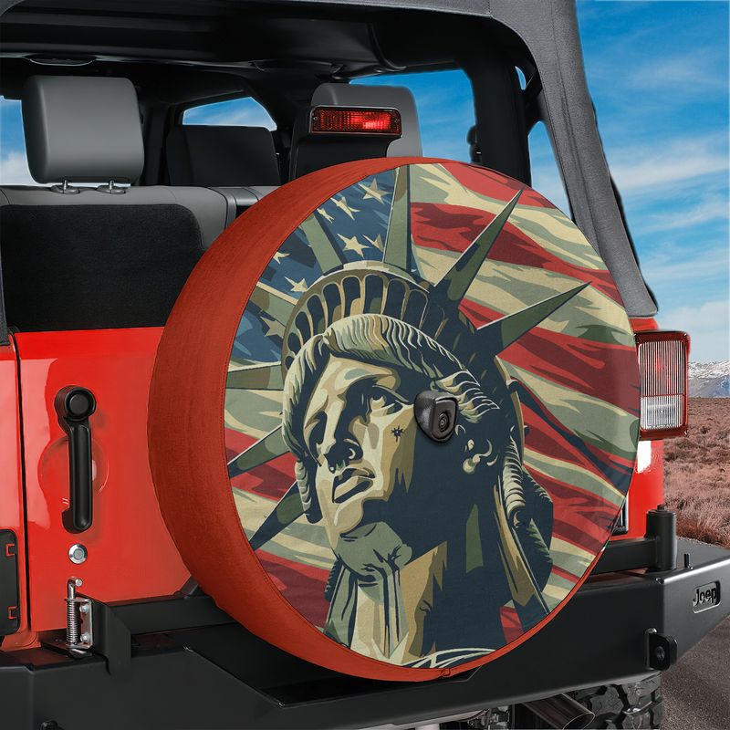 Lady Liberty's Glory spare tire cover on a black Jeep Wrangler with Statue of Liberty flag backdrop