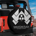 Nakatomi Plaza spare tire cover mounted on a red Jeep Wrangler tailgate with desert mountain backdrop
