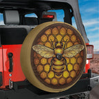 Honeycomb bee spare tire cover installed on a red Jeep Wrangler rear hatch in a desert landscape outdoor scene