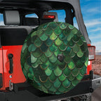 Green mermaid scale spare tire cover mounted on a red Jeep Wrangler tailgate with desert mountain backdrop